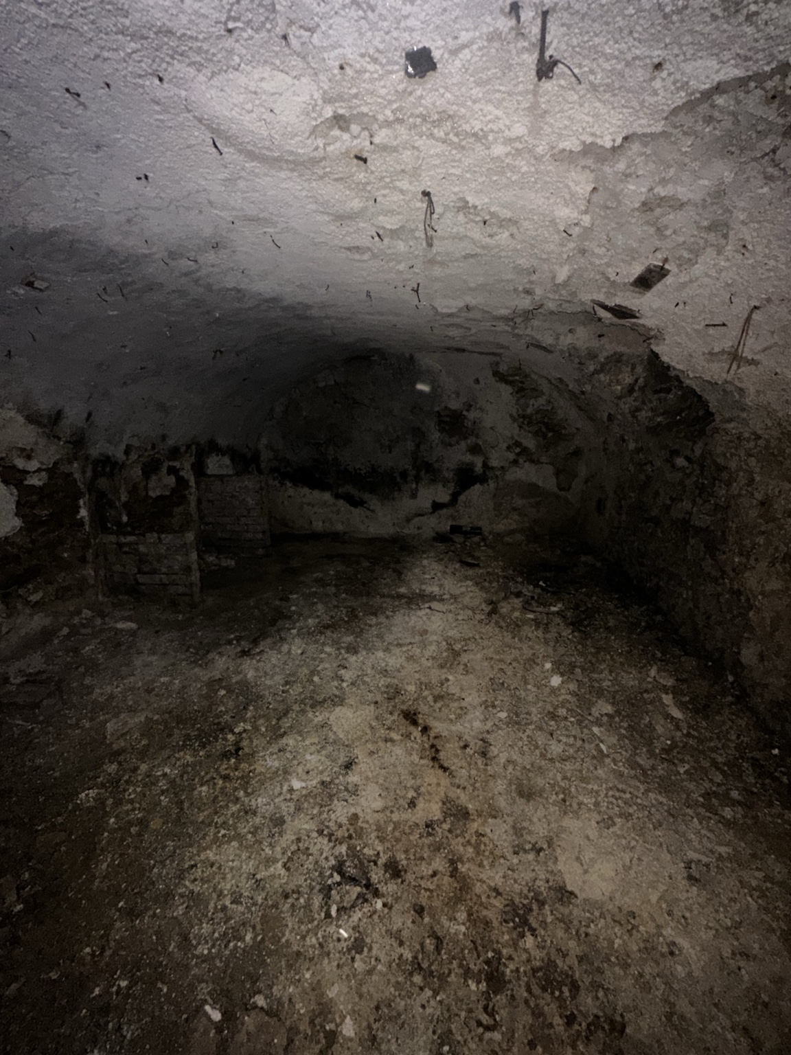 Parois et sol d'une cave humide à Versailles montrant des dégradations avancées et des traces d'humidité persistante